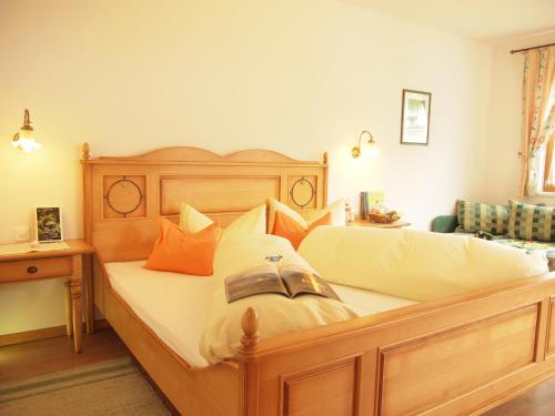 ein Schlafzimmer mit einem großen Holzbett mit Kissen in der Unterkunft Apart-Garni Motnaida in Samnaun