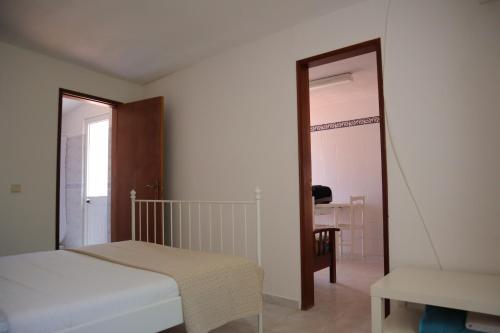 a bedroom with a bed and a chair and a mirror at Salema Beach Private Villa in Salema