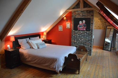 ein Schlafzimmer mit einem großen Bett und einer Ziegelwand in der Unterkunft Chambres d'Hôtes Les Chaufourniers in Crouay