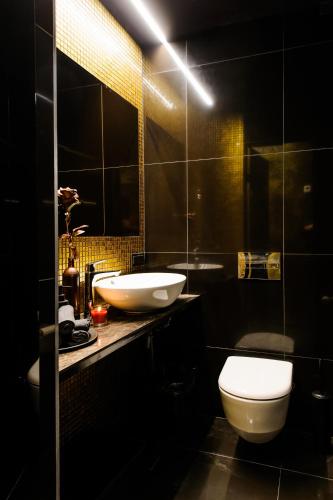 a bathroom with a white sink and a toilet at Apartments in Kaunas city centre with Jacuzzi bath in Kaunas