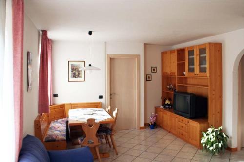 a living room with a table and a dining room at Appartamenti Piazzi in Tesero