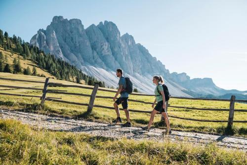 a man and a woman walking down a dirt road at Ferienwohnungen Trogerhof in Ora/Auer