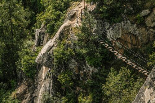 a suspension bridge on the side of a mountain at Ferienwohnungen Trogerhof in Ora/Auer