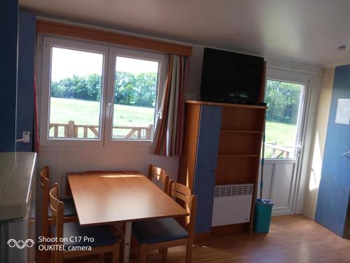 a small dining room with a table and a television at Les chalets de Bes Le Montagnol in Lacombe
