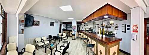 a bar in a restaurant with white chairs at Hostal Gabino in Isla