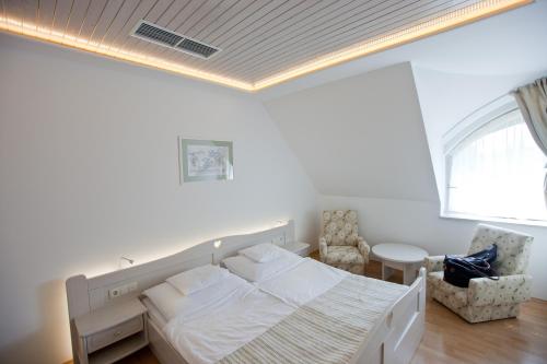 a bedroom with a bed and a table and a window at Tornácos Hotel - Hegykő in Hegykő