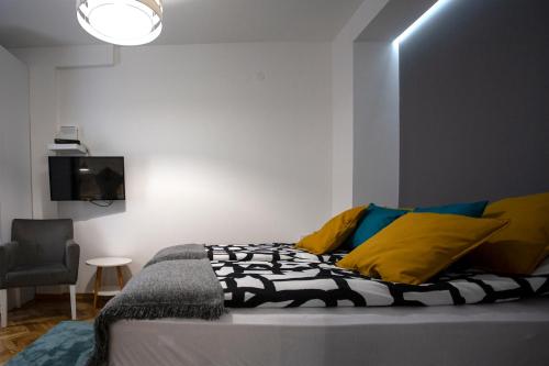 1 dormitorio con 1 cama, 1 silla y TV en DK Apartment, en Novi Sad