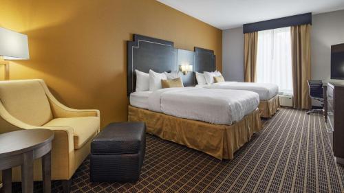 a hotel room with two beds and a table and chairs at Best Western Plus Regency Park in Walker