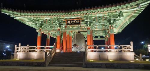a large building with stairs and a sign at night at Gyeongju BonghwangMansion in Gyeongju