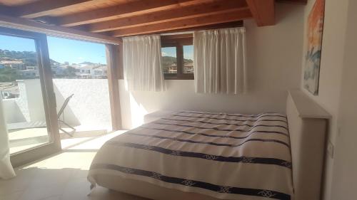 ein Schlafzimmer mit einem Bett und einem großen Fenster in der Unterkunft Porto Rotondo in Porto Rotondo