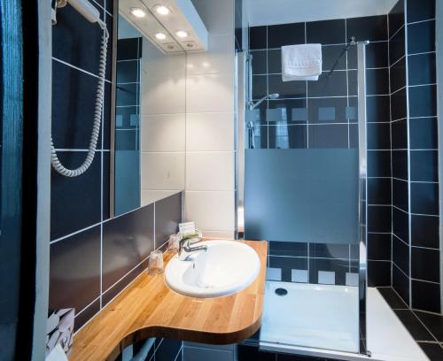 a bathroom with a sink and a shower at Hôtel Les Tilleuls, Bourges in Bourges
