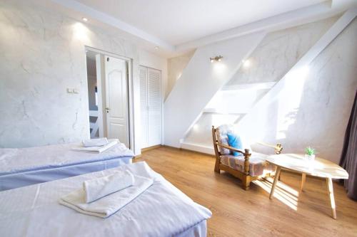 a bedroom with two beds and a table and a window at Rezydencja Viva in Poronin