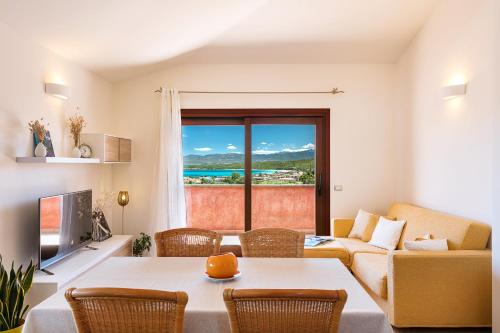 a living room with a table and chairs and a couch at Homey Experience - Terrace Sea View Apartment in Olbia