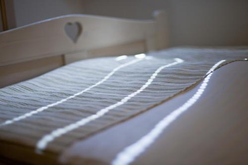 a close up of a bed with white sheets at Tornácos Hotel - Hegykő in Hegykő