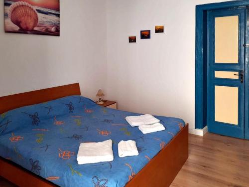 a bedroom with a blue bed with towels on it at Flamingo Room in Castellammare del Golfo