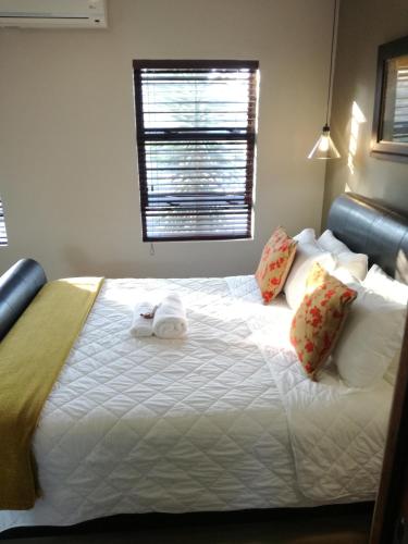 a bedroom with a bed with a towel on it at Belmont Guesthouse in Bloemfontein