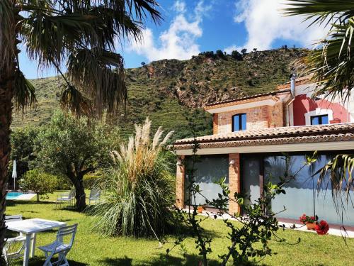 a house with a table and a mountain in the background at Il Mandorlo in Amantea