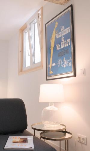 a table with a lamp and a picture on the wall at NUEVO Katu Kale Apartamentuak CENTRO HISTORICO in Getaria