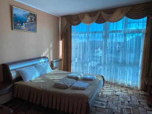 1 dormitorio con cama y ventana grande en Zoremma Mini-hotel, en Adler