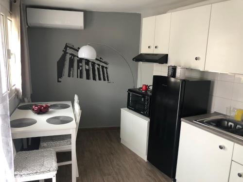 a small kitchen with a black refrigerator and a table at Cozy studio apartment in the heart of Athens in Athens