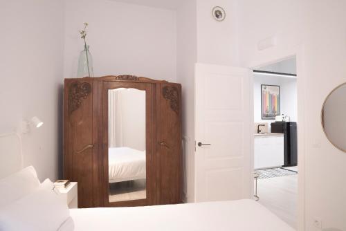 a bedroom with a wooden cabinet and a mirror at NUEVO Katu Kale Apartamentuak CENTRO HISTORICO in Getaria
