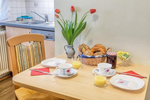 a table with plates and cups and a basket of bread at Top Appartements Taufner in Waidhofen an der Thaya