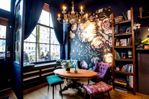 une chambre avec une table, des chaises et une fenêtre dans l'établissement Rosalia's Menagerie Cocktail Lounge & InnUpstairs, à Amsterdam