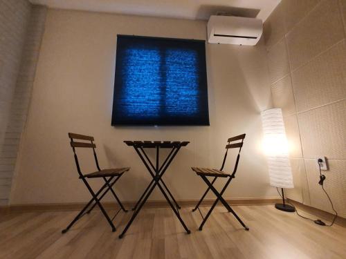 a room with two chairs and a blue window at Gyeongju BonghwangMansion in Gyeongju