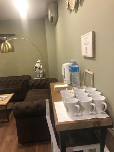 a group of white cups on a table in a living room at Hotel Radha in Hospitalet de Llobregat