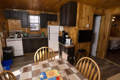 a kitchen with a table and chairs in a cabin at North Rustico Motel & Cottages in North Rustico