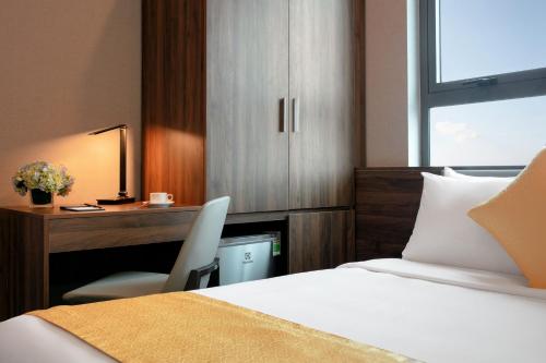 a bedroom with a bed and a desk with a chair at Golden Season Hotel in Ninh Binh