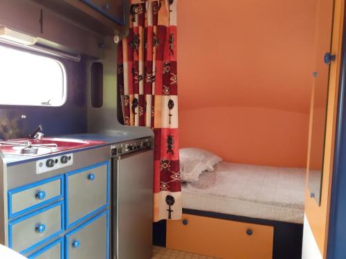 a small kitchen with a bed and a sink in a room at Maison d'Hôtes Afrika du Queyroux in Ginestet