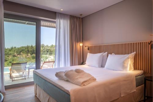 a bedroom with a large bed with a large window at Isola Verde in Syvota