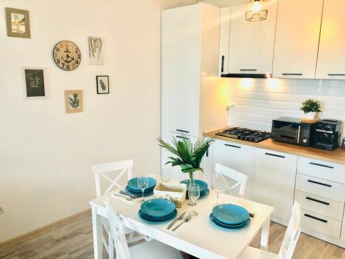una cucina con tavolo bianco e piatti blu di Sega Residence Alessia 22 a Mamaia Nord - Năvodari