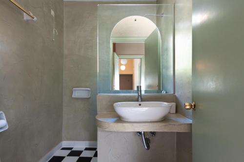 a bathroom with a sink and a mirror at Kalamitsi Hotel in Kardamyli