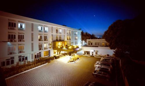 un gran edificio blanco con patio por la noche en The Cindrella Hotel en Siliguri