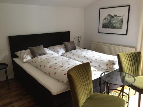 - une chambre avec un lit, une table et des chaises dans l'établissement Haus Ebner, à Vandans