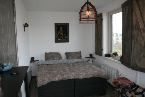 een slaapkamer met een bed en een raam bij B&B Het kasteel in Almere