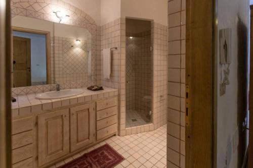 a bathroom with a sink and a shower and a mirror at Villa Con Piscina Vista Mare in Cala Bitta