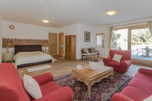 a living room with red furniture and a bed at Villa Con Piscina Vista Mare in Cala Bitta
