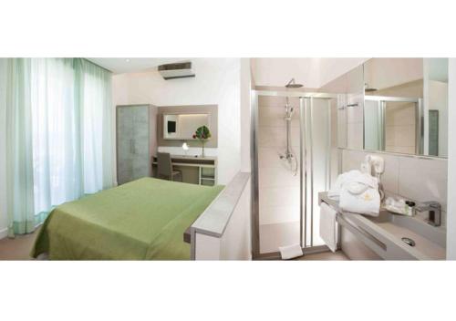 a bathroom with a green bed and a shower at Hotel Beaurivage in Cattolica
