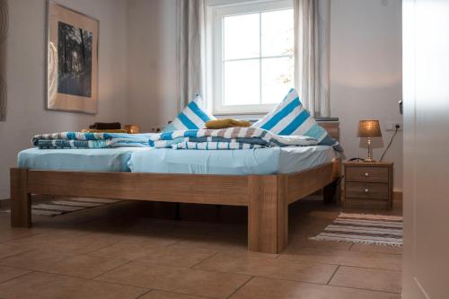 a bedroom with a bed with blue sheets and a window at Ferienhaus Wasserfall in Bestwig