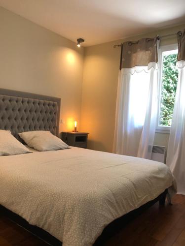 Un dormitorio con una cama grande y una ventana en Maison avec piscine privative, en Nyons