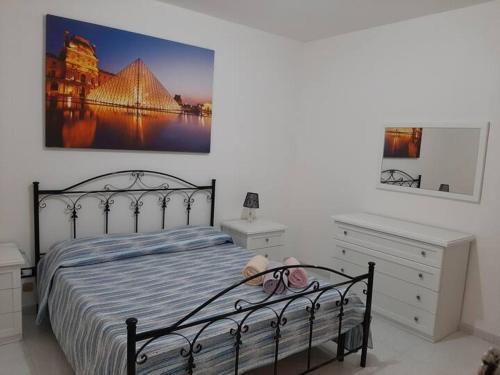 a bedroom with a bed and a dresser and a picture at Colle Alto Pachino - Marzamemi in Pachino