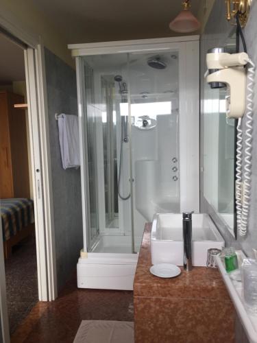 ein Bad mit einer Dusche und einem Waschbecken in der Unterkunft Hotel Consuelo in Lignano Sabbiadoro