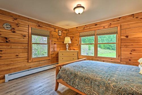 a bedroom with wooden walls and a bed and windows at Catskills Home with Deck and Game Room 14 Mi to Ski! in Prattsville