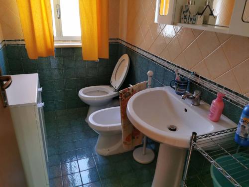 La salle de bains est pourvue de toilettes et d'un lavabo. dans l'établissement L'angolo di Paradiso, à Alcamo