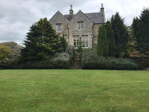 an old stone house with a large yard at Hundalee House in Jedburgh