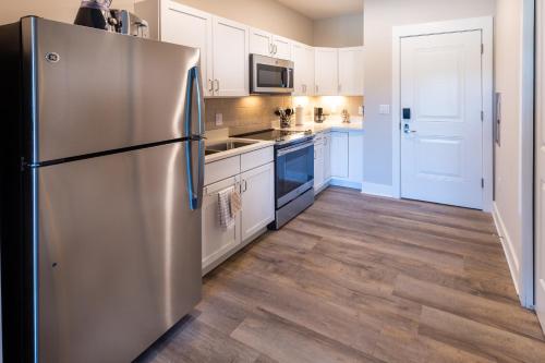 a kitchen with a stainless steel refrigerator and white cabinets at Lakeside Lodge Clemson in Clemson