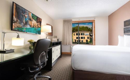 a hotel room with a bed and a desk and a window at The VUE Boutique Hotel & Boathouse in Wisconsin Dells